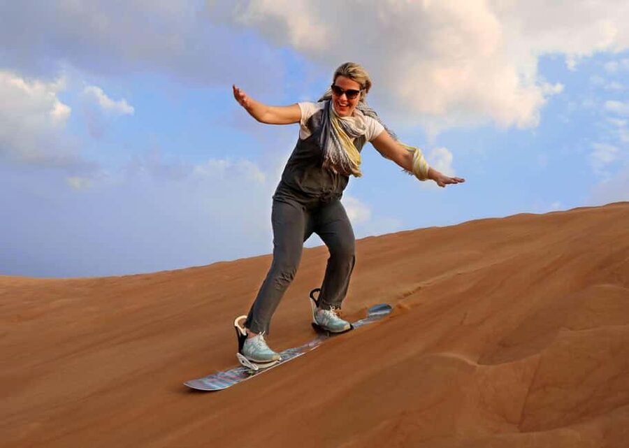 Desert Safari Dubai with Camel Ride, Sandboarding & Dinner - Sandboarding across the dunes