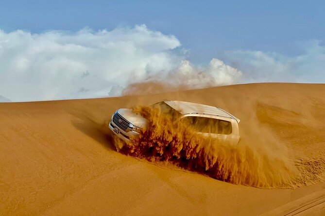 Dubai Desert Safari: Dune Bashing, Camel Ride, Sandsurf & 5<em> BBQ – Key points to know before you book’ /></p>
<ul>
<li><strong>Lahbab’s red dunes provide the main thrill:</strong> The safari heads beyond the city for dune bashing, sandboarding, and a sunset photo stop.</li>
<li><strong>The 4×4 ride is the heart of the outing:</strong> The drive across the dunes is described as longer than what many other operators offer.</li>
<li><strong>Camel time is short but repeatable:</strong> You can take a brief ride around camp, feed the camel, and repeat the experience.</li>
<li><strong>The camp covers several traditions in one stop:</strong> Expect henna, Arabic dress, falcon photographs, coffee, dates, sweets, shisha access, and live performances.</li>
<li><strong>The $27.91 price covers a lot:</strong> Transport, activities, drinks, dinner, and entertainment are included, but quad bikes, shisha, alcohol, and VIP seating cost extra.</li>
<li><strong>Service can shape the day:</strong> Drivers Ahmed and Ali receive particular praise, while planning and camp arrangements may not suit every booking party.</li>
</ul>
<h2 id="from-dubai-streets-to-lahbabs-red-dunes">From Dubai streets to Lahbab’s red dunes</h2>
<p><img width="669" height="446" decoding="async" src=